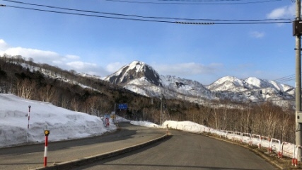 雪解けが進む峠の頂上の写真