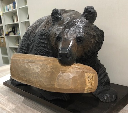 新聞を咥える木彫り熊