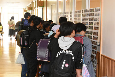 掲示された写真に集まる子供たち