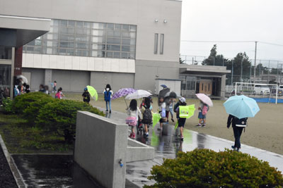 学校が開くのを待つ児童