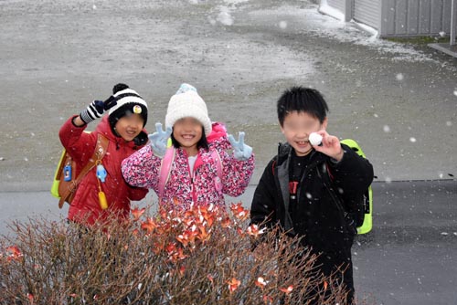 雪玉で喜ぶ子供たち