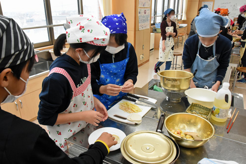 餃子のあんをくるむ子供たち