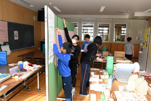 一生懸命掲示作業をする児童