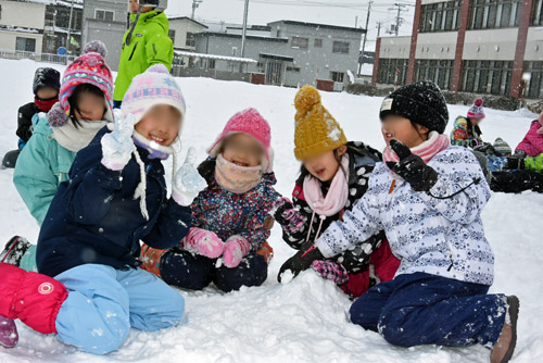 雪で小さな山を作ってピース