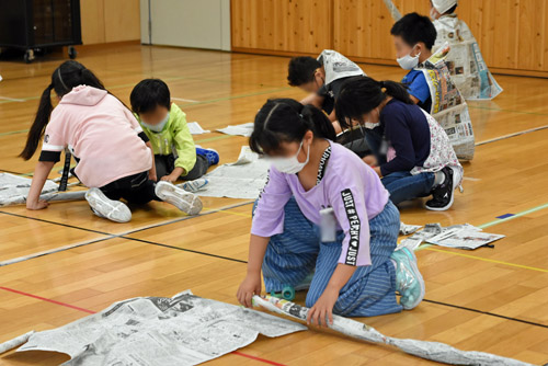 新聞紙を丸める子供