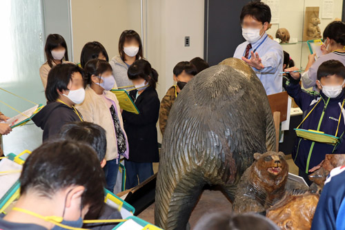 木彫り熊の説明を聞く子供たち