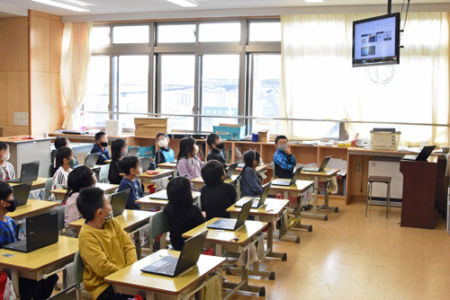 テレビの説明を熱心に聞く子供たち