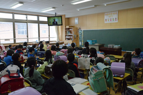教室で真剣に話を聞く子供