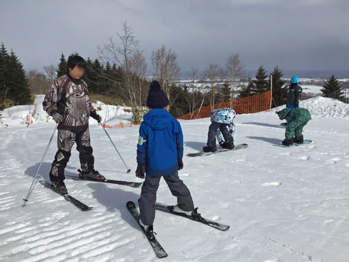 土曜日、子供にスキーを教えるお父さん